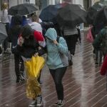 Imagen de archivo de varias personas protegiéndose de la lluvia