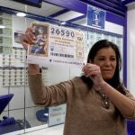 GRAF3260 SALAMANCA. 22/12/2019.- Un despacho situado en el centro comercial Carrefour de Salamanca, en la Avenida de Agustinos Recoletos, ha repartido 100 millones de euros en 25 series del Gordo, el primer premio del sorteo extraordinario de la Lotería de Navidad, que ha salido a las 9,20 horas y recaído en el número 26.590.En la foto, la encargada del despacho de loteria muestra el número agraciado. EFE/J.M. Garcia