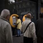 Imagen de archivo de varias personas haciendo cola en el cajero de una entidad bancaria