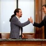 El candidato a la investidura, Pedro Sánchez (d), y el líder de Podemos, Pablo Iglesias (i), estrechan sus manos tras el acto de firma del acuerdo