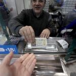 Un cliente compra lotería del niño en una administración