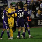 Lunin es felicitado por sus compañeros tras detener dos lanzamientos en la tanda de penaltis ante el Marbella en Copa