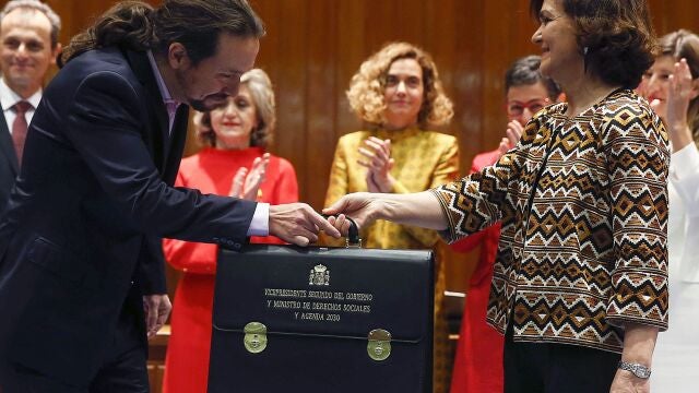 -FOTODELDIA- GRAF1433. MADRID, 13/01/2020.- El nuevo Vicepresidente de Derechos Sociales y Agenda 2030, Pablo Iglesias (i) recibe su cartera de la vicepresidenta primera y ministra de Presidencia y Relaciones con las Cortes, Carmen Calvo (d) durante la toma de posesión en un acto celebrado en la sede del Ministerio de Sanidad, Consumo y Bienestar Social en Madrid este lunes 13 de enero de 2020. EFE/Paco Campos