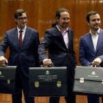 GRAF1363. MADRID, 13/01/2020.- El nuevo Vicepresidente de Derechos Sociales y Agenda 2030, Pablo Iglesias (c) posa con su cartera junto al nuevo ministro de Consumo, Alberto Garzón (d) y el ministro de Sanidad, Salvador Illa (i) durante la toma de posesión en un acto celebrado en la sede del Ministerio de Sanidad, Consumo y Bienestar Social en Madrid este lunes 13 de enero de 2020. EFE/Paco Campos