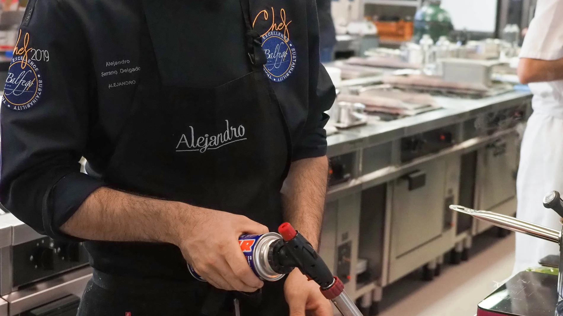 Alejandro Serrano cocinando su plato Secreto y finas hierbas de mar y montaña