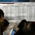 Varios estudiantes miran las listas para ver el aula en el que se examinan para las plazas de Médico Interino residente (MIR) de 2020