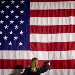 Imagen de una asistente planchando la bandera estadounidense en el Caucus de Iowa (EE.UU).