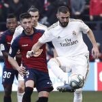 El delantero francés Karim Benzema (d) controla el balón en el partido ante Osasuna, correspondiente a la jornada 23 de LaLiga Santander que se disputa este domingo en el estadio El Sadar de Pamplona. EFE/Jesús Diges