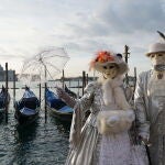 Una pareja posa enmasacarada en el embarcadero de la Plaza de San Marcos de Venecia/EPA