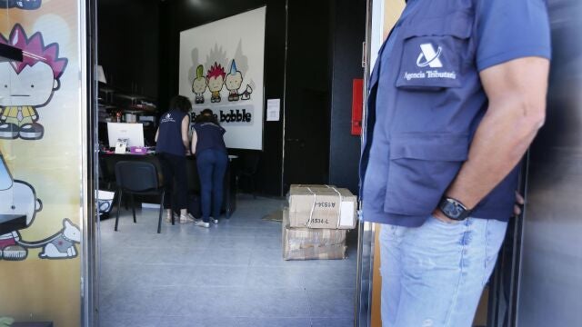 Agentes de la Agencia Tributaria en la puerta de una de las naves con productos procedentes de China registradas en el polígono de El Carrús (Elche) donde se leva hoy a cabo una operación nacional contra la economía sumergida y el fraude fiscal en importaciones, distribución y venta de productos procedentes de China con el registro de 61 naves en polígonos de 11 comunidades autónomas e inspecciones a 66 sociedades. EFE/Manuel Lorenzo
