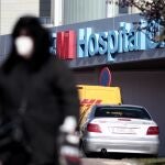 Un hombre con mascarilla camina por las zonas exteriores del Hospital de Torrejón, donde se encuentran hospitalizados varios pacientes por dar positivo en coronavirus.