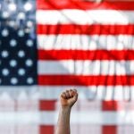 Un seguidor de Bernie Sanders alza el puño en un acto celebrado en Richmond, California