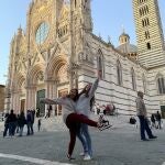 Fotografía facilitada por el grupo de Erasmus españoles en Siena de dos estudiantes que posan frente a la Catedral de Siena, en la región de Toscana (Italia). El brote de coronavirus ha provocado que algunos se planteen volver a casa, pero no parece estar siendo la opción mayoritaria. Tras conocerse ayer que Italia ha cerrado colegios y universidades hasta el 15 de marzo, el Ministerio de Universidades reconoció que tanto esa medida como las que se están tomando en Francia y Grecia pueden afectar las estancias del programa Erasmus+ y, por tanto, "sería posible aplicar la cláusula de fuerza mayor para cancelarlas o posponerlas".