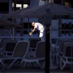 Un trabajador de un hotel limpia la escalera de la piscina