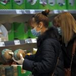 Dos mujeres con mascarilla y guantes se abastecen en un supermercado en Bilbao donde este viernes el gobierno vasco ha decretado el estado de alarma en la región. EFE/LUIS TEJIDO