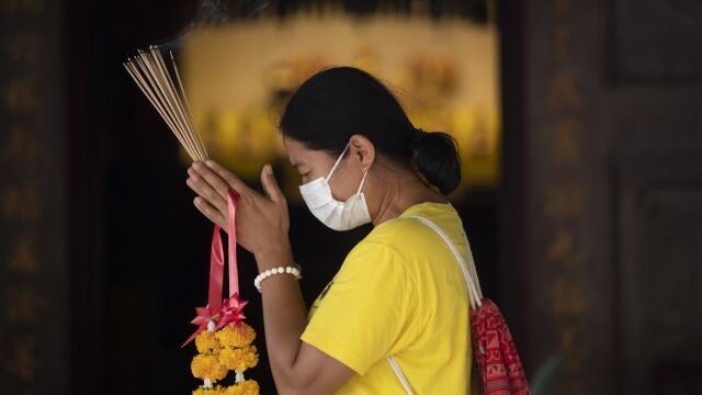 Una mujer con mascarilla hace sus plegarias en el templo de Leng Nuei Yee en Bangkok, este lunes Una mujer con mascarilla hace sus plegarias en el templo de Leng Nuei Yee en Bangkok, este lunes