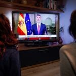 Dos personas ven el discurso de Felipe VI en marzo de 2020 que provocó el comentario en la red social del tuitero condenado
