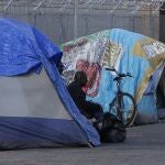 Un "homeless" a la entrada de su tienda en un campamento de Sacramento, en California