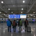 Passengers check a flight announcement board at Eleftherios Venizelos International Airport in Athens, Saturday, March 21, 2020. The government banned travel to Greece for all citizens from non-European Union countries and people entering the country would be asked to remain in self-quarantine for 14 days. For some people the COVID-19 coronavirus causes only mild or moderate symptoms, but for some it causes severe illness.(AP Photo/Yorgos Karahalis)