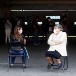 Dos mujeres conversan mientras esperan en la jornada de vacunación contra la influenza en el Estadio Bicentenario de la Florida este sábado, en Santiago (Chile)