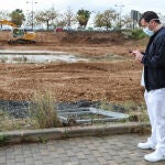 Un sanitario protegido con una mascarilla junto a las obras de construcción de un hospital de campaña junto al Hospital La Fe para atender a enfermos de covid-19