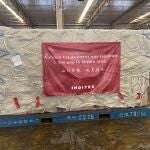 Paquete de Inditex en un carguero preparado para ser enviado en el que se lee 'Aunque los océanos nos separen, nos une la misma luna'.