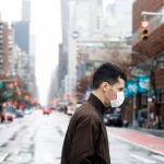 New York (United States), 28/03/2020.- A man in a protective mask crosses a quiet avenue in New York, New York, USA, on 28 March 2020. The city is continuing to deal with one of the country'Äôs largest outbreak of COVID-19 cases as the coronavirus spreads. The region has shutdown of all non-essential businesses in an effort to keep the city'Äôs hospital system from being overwhelmed with seriously ill COVID-19 patients. (Estados Unidos, Nueva York) EFE/EPA/JUSTIN LANE