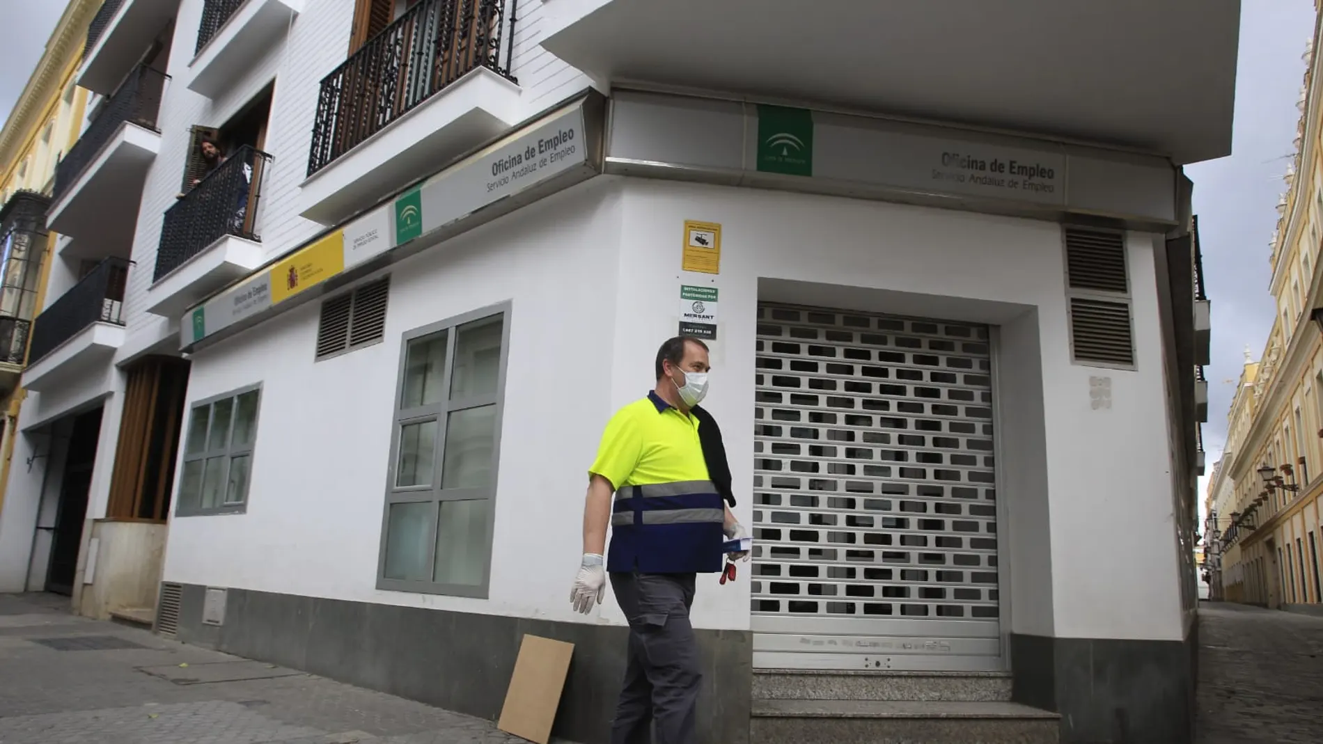 Un trabajador con mascarilla pasa por una oficina de Empleo de la Junta de Andalucía
