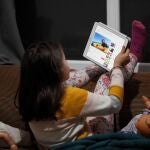 Una niña juega con su tablet durante el confinamiento