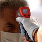 Un empleado de un supermercado de la zona de La Mata de Torrevieja toma la temperatura a sus clientes para prevenir que gente infectada acceda a la tienda y pueda contaminar productos y clientela