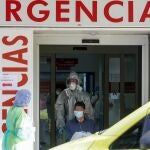Un sanitario empuja una silla de ruedas con un enfermo leve de Covid-19 para su posterior traslado desde el Hospital de La Princesa al hospital de campaña en IFEMA
