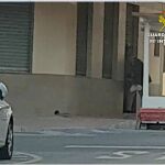 Un cliente entra en el bar con la persiana medio bajada