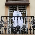 La bata y la mascarilla de una enfermera colgadas en un balcón de Valencia