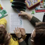 Un niño estudia y hace los deberes en casa con la ayuda de su madre