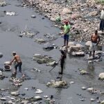 -FOTODELDÍA- AME2785. TEGUCIGALPA (HONDURAS), 15/04/2020.- Varios hombres buscan sustento este miércoles en un río contaminado, en Tegucigalpa (Honduras). Honduras atraviesa un panorama "sombrío" por la pandemia del coronavirus, que ha causado la suspensión temporal de unos 150.000 trabajadores, la paralización de la actividad económica y amenaza con destruir otros miles de empleos, principalmente en el sector informal. EFE/Gustavo Amador