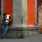 AME3196. CIUDAD DE MÉXICO (MÉXICO), 16/04/2020.- Un hombre observa su teléfono móvil en una calle del centro histórico de Ciudad de México. México extenderá las medidas de distanciamiento social hasta el 30 de mayo para evitar que se dispare la pandemia del coronavirus en el país y ante el reto, cada vez más patente, de evitar que colapse el sistema de salud. EFE/Jorge Núñez