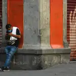 AME3196. CIUDAD DE MÉXICO (MÉXICO), 16/04/2020.- Un hombre observa su teléfono móvil en una calle del centro histórico de Ciudad de México. México extenderá las medidas de distanciamiento social hasta el 30 de mayo para evitar que se dispare la pandemia del coronavirus en el país y ante el reto, cada vez más patente, de evitar que colapse el sistema de salud. EFE/Jorge Núñez