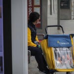 Una trabajadora de correos en una parada de autobús. María José López / Europa Press