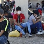 Cientos de personas descansan junto a la autopista Panamericana en Lima, en su recorrido a pie hacia el departamento de Apurimac