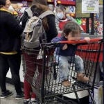 Niña chupa un carro del supermercado