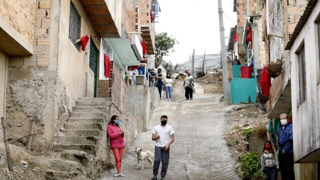 Familias esperan la entrega de mercados, mientras tienen colgados trapos rojos en sus casas como forma de manifestar la necesidad de alimentos en el sur de Bogotá (Colombia).