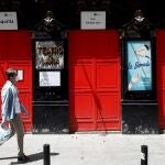 Un hombre ataviado con una mascarilla sanitaria pasa frente al Teatro Lara del madrileño barrio de Malasaña