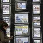 Una mujer pasa por delante de una inmobiliaria de venta y alquiler en Bilbao
