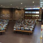 Fotos de los feligreses en los bancos de la Iglesia de la Virgen de los Llanos, Cuatro Vientos