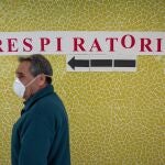 Un usuario del Centro de Salud Juan XXIII frente a un letrero que indica la dirección hacia la zona de atención a pacientes con síntomas de covid-19