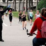 Un agente de la Policía Local ordena el sentido de circulación de los deportistas en el antiguo cauce del Turia