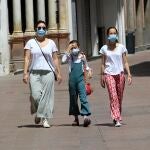 Una mujer pasea con sus hijas por Sevilla protegidas con mascarillas quirúrgicas