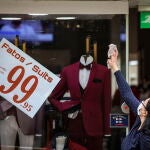 Una mujer prepara su tienda de moda en Lisboa para la reapertura comercial que arrancó el 4 de mayo