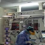 Imagen de archivo de una sanitaria prestando atención a un paciente Covid en el Virgen Macarena