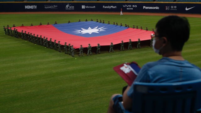 Soldados taiwaneses portan la bandera de Taiwán antes de un partido de béisbol en Nuevo Taipéi, al que asistieron mil personas